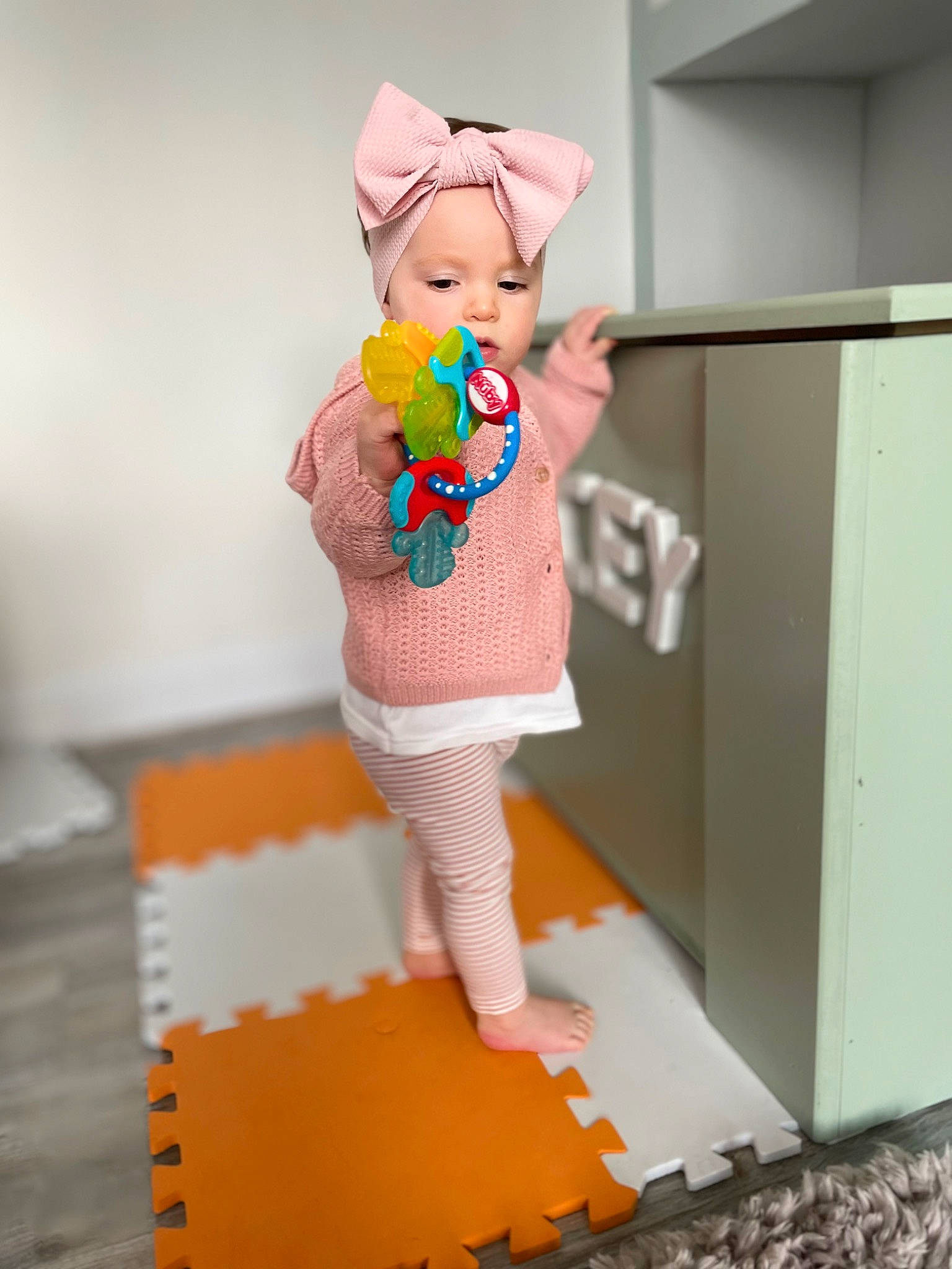 Darcey is registered to the contest to win money with this photo: art, baby_toddler_clothing, child, costume_hat, doll, fashion_design, figurine, flooring, hat, headwear, linens, pattern, person, pink, play, room, sleeve, stuffed_toy, toy, wood