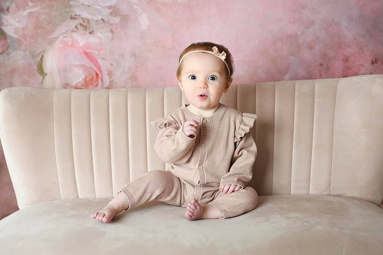 Darcey joined the competition — help win amazing prizes! baby, baby_toddler_clothing, comfort, couch, dress, fashion_accessory, flash_photography, foot, fur, happy, headpiece, human_leg, knee, magenta, peach, person, pink, sitting, sleeve, toddler