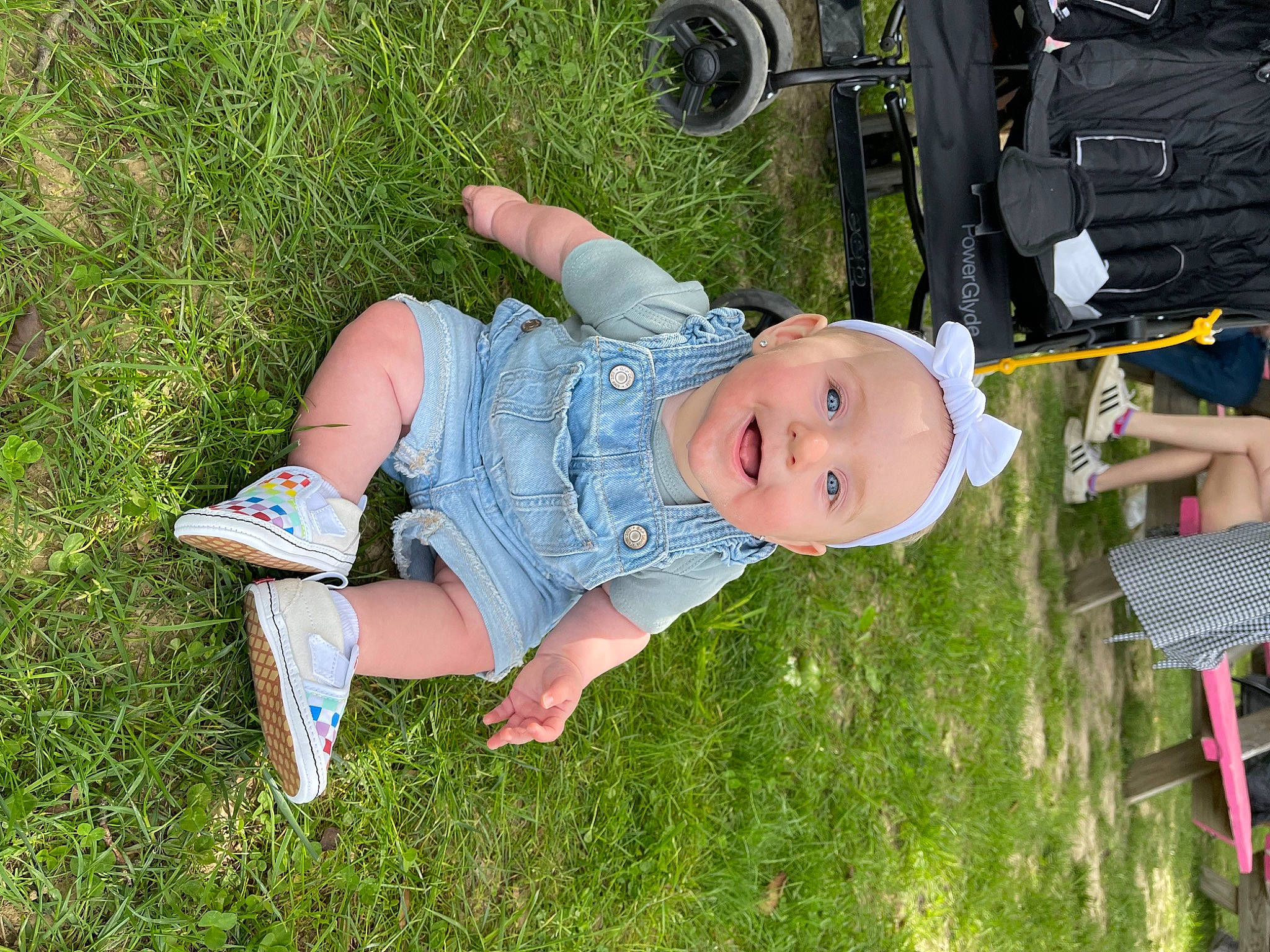 Emmerson is registered to the contest to win money with this photo: automotive_tire, baby, baby_toddler_clothing, child, fun, grass, green, hat, lawn, leg, leisure, people_in_nature, person, recreation, shoe, smile, sneakers, tire, toddler, walking_shoe