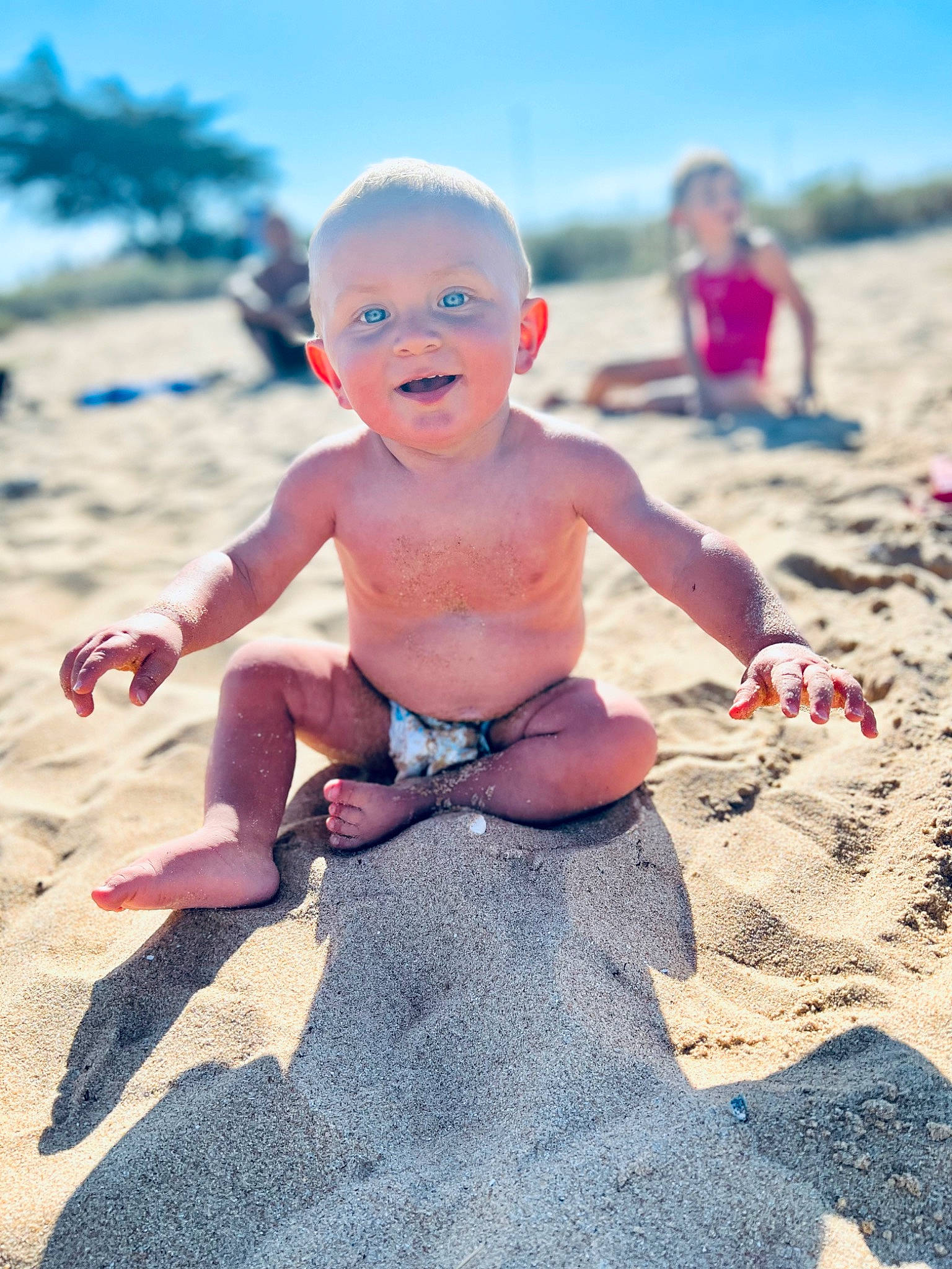 Eyden a rejoint le concours — aidez-le/la à gagner de superbes lots ! baby, barefoot, beach, finger, foot, fun, happy, hat, human_leg, leisure, people_in_nature, people_on_beach, person, sand, shorts, sitting, sky, smile, thumb, toddler