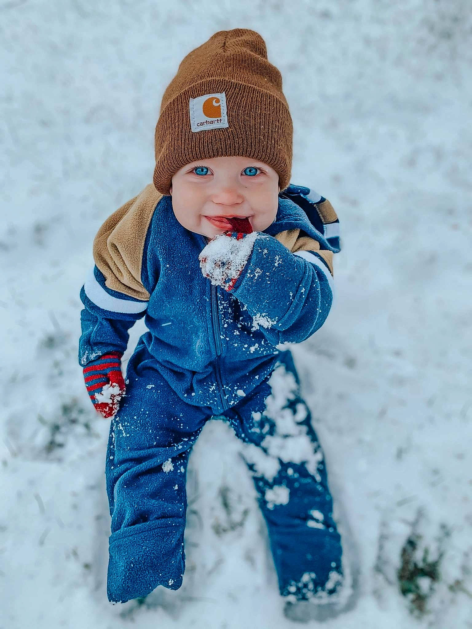 Branson is registered to the contest to win money with this photo: baby_toddler_clothing, beanie, bonnet, cheek, child, craft, creative_arts, crochet, headgear, headwear, joy, knit_cap, knitting, person, playing_in_the_snow, snow, thread, toy, winter, wool