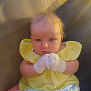 Delannie joined the competition — help win amazing prizes! baby, infant, yellow_dress, mittens, couch, soft_toys, blue_shorts, curly_hair, indoors, cute, portrait, child, seated, looking_at_camera, plush, furniture, skin, head, person, cozy