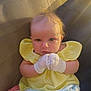 baby, infant, yellow_dress, mittens, couch, soft_toys, blue_shorts, curly_hair, indoors, cute, portrait, child, seated, looking_at_camera, plush, furniture, skin, head, person, cozy