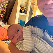 Wyatt is registered to the contest to win money with this photo: baby, adult, smile, indoor, portrait, striped_clothing, onesie, arm, face, window, light, flower_art, decor, candid, holding, warm_light, skin, hair, person, child