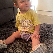 Reign joined the competition — help win amazing prizes! baby, carpet, casual_clothing, child, cute, floor, furniture, good_vibes, happy, indoor, living_room, person, pony_tail, shoes, sitting, smiling, toddler, white_bow, yellow_shirt, young_child