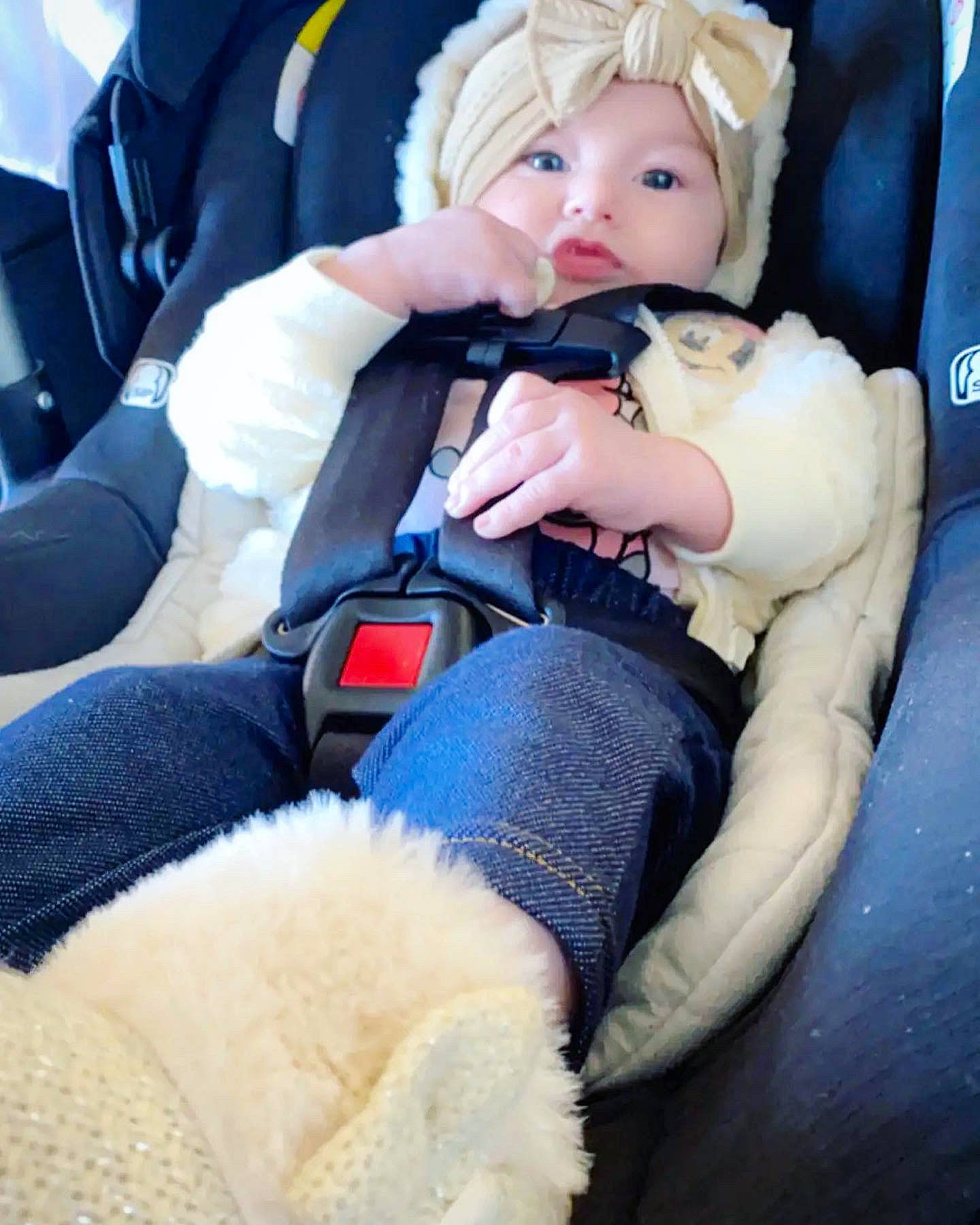 Leia is registered to the contest to win money with this photo: arm, baby, baby_products, baby_toddler_clothing, car_seat, car_seat_cover, cheek, child, comfort, doll, electric_blue, finger, headwear, lap, nail, person, seat_belt, sitting, skin, stuffed_toy