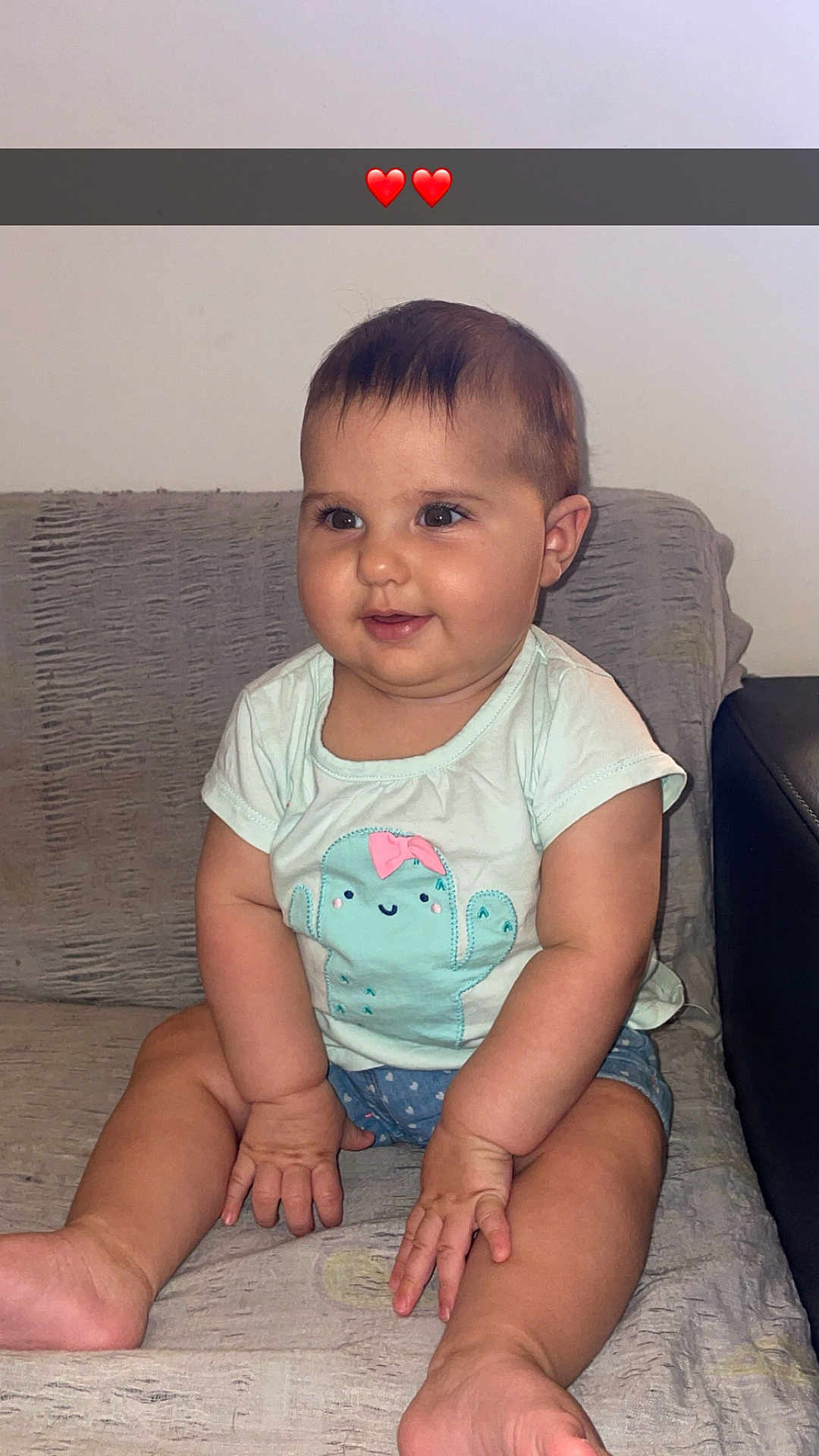 Emma a rejoint le concours — aidez-le/la à gagner de superbes lots ! baby, child, infant, sitting, couch, clothing, shorts, shirt, cute, happy, smiling, indoors, person, face, hands, legs, feet, heart_emojis, wall, blanket