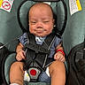 baby, infant, child, car_seat, harness, buckled, sitting, portrait, face, smiling, awake, clothing, sock, bracelet, medical_tubing, warning_label, indoor, close_up,  안전, newborn