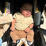 baby, infant, sleeping, car_seat, oxygen_tube, medical_equipment, onesie, clothing, sneakers, blanket, stuffed_toy, portrait, indoors, transportation, sitting, peaceful, face, hands, legs, closeup