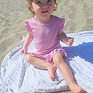 Ruby joined the competition — help win amazing prizes! child, toddler, beach, sand, blanket, hat, yellow_hat, pink_clothing, smiling, happy, sunlight, outdoor, summer, barefoot, cute, person, portrait, sitting, playful, daytime