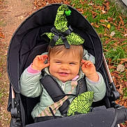 Lina a rejoint le concours — aidez-le/la à gagner de superbes lots ! toddler, child, stroller, witch_hat, green_hat, autumn, leaves, outdoor, parked_cars, playful, smiling, jacket, baby, cute, person, seasonal, fall, happy, nature, casual