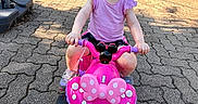 Josefina-Ravenna joined the competition — help win amazing prizes! toddler, child, pink_bike, toy_vehicle, outdoor, paved_driveway, pink_clothing, purple_shoes, hair_bow, garage_door, backpack, spiderman, sunlight, shadow, smiling, playtime, summer, person, cute, casual