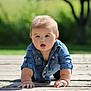 Carter is registered to the contest to win money with this photo: baby, child, denim_shirt, crawling, wooden_deck, outdoor, greenery, curious, cute, infant, portrait, nature, sunlight, hands, face, young, casual_clothing, daylight, expression, front_view