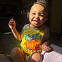 Amarion is registered to the contest to win money with this photo: child, toddler, smile, happy, yellow_shirt, truck_print, indoor, sunlight, portrait, cute, baby, sitting, gesture, face, person, home, cozy, light_and_shadow, expression, joyful