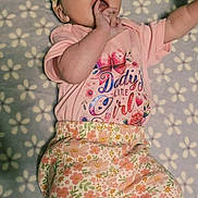 Vivian joined the competition — help win amazing prizes! baby, infant, child, portrait, lying_down, smiling, floral_bow, hair_accessory, pink_clothing, floral_pattern, blanket, indoors, bed, cute, fashion, hand_in_mouth, barefoot, face, single_person, photography