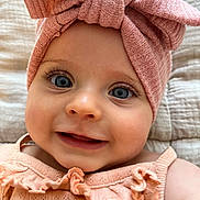 Kascillia a rejoint le concours — aidez-le/la à gagner de superbes lots ! baby, child, face, smile, blue_eyes, headband, bow, pink, knitted, clothing, portrait, close_up, infant, cute, ruffles, soft_texture, blanket, happy, young_child, skin