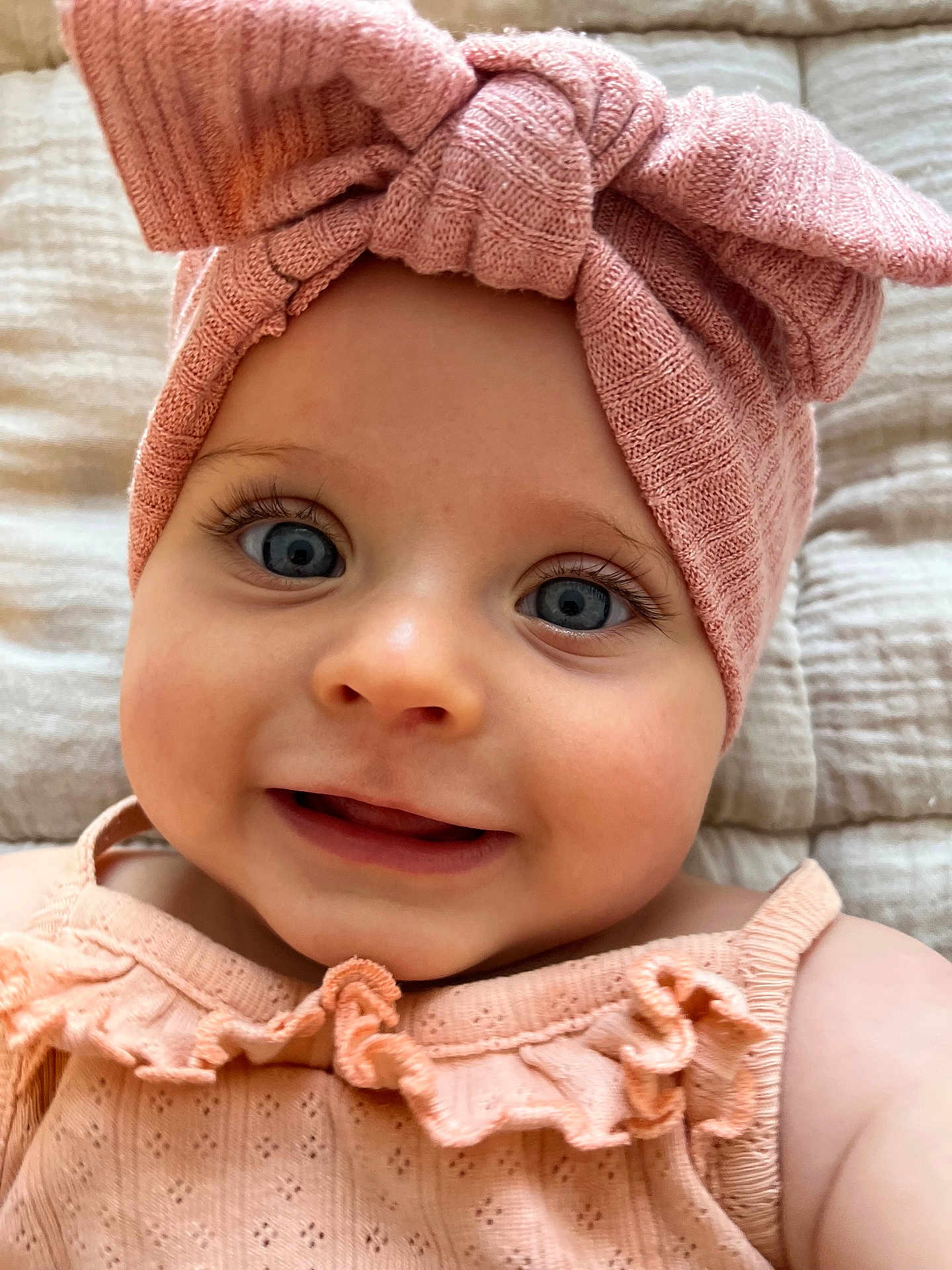 Kascillia a rejoint le concours — aidez-le/la à gagner de superbes lots ! baby, child, face, smile, blue_eyes, headband, bow, pink, knitted, clothing, portrait, close_up, infant, cute, ruffles, soft_texture, blanket, happy, young_child, skin