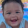 baby, infant, child, smiling, happy, portrait, close_up, face, eyes, open_mouth, drool, tousled_hair, sleeveless_shirt, blue_clothing, sitting, indoor, colorful_background, blanket, photography, joy