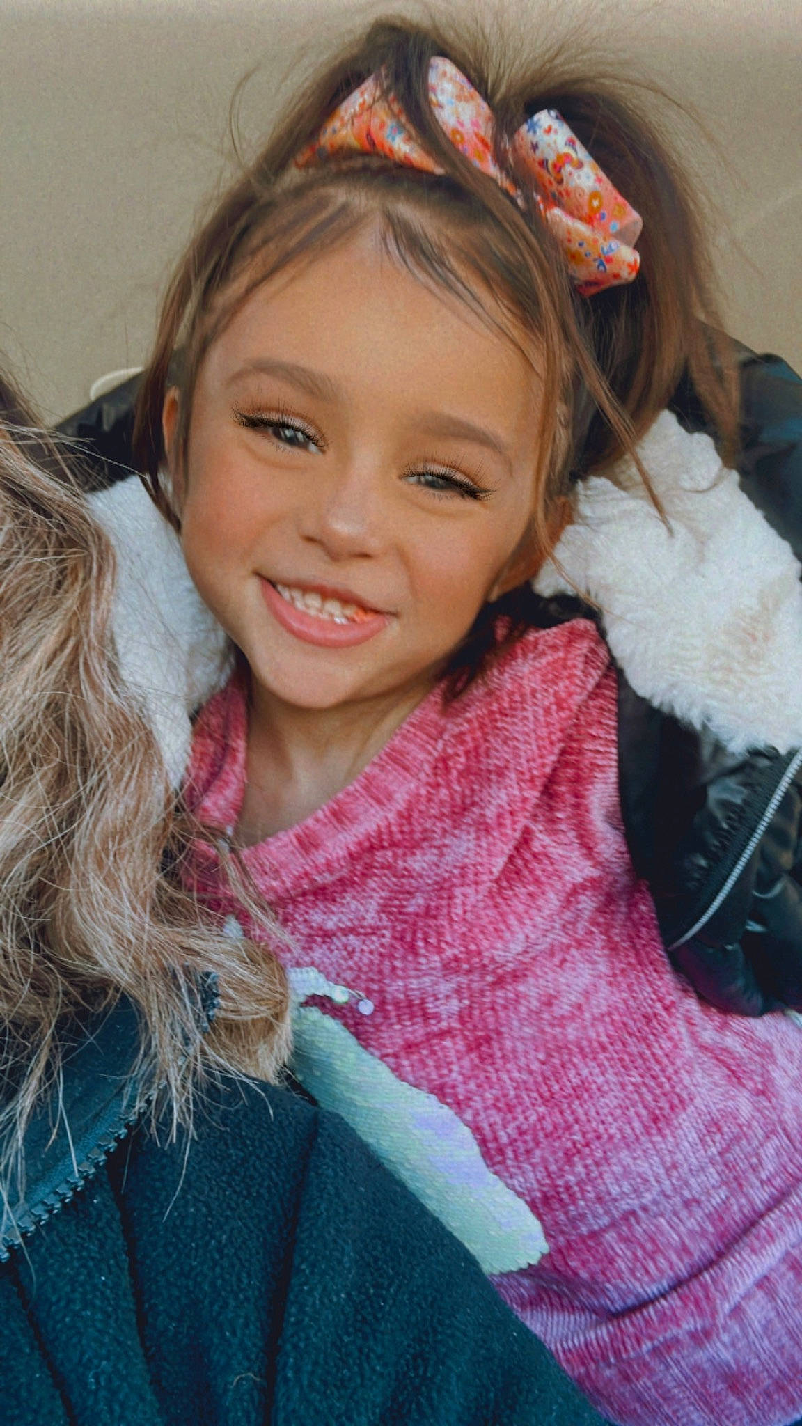 Mia is registered to the contest to win money with this photo: cheek, chin, cool, eye, eyebrow, eyelash, facial_expression, hair, happy, head, iris, joy, lip, long_hair, neck, outerwear, person, pink, skin, sleeve