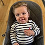 baby, child, smiling, striped_clothing, blue_eyes, hair, padded_chair, indoor, wooden_floor, cute, portrait, hand, sitting, infant, happy, face, clothing, person, young_child, comfortable