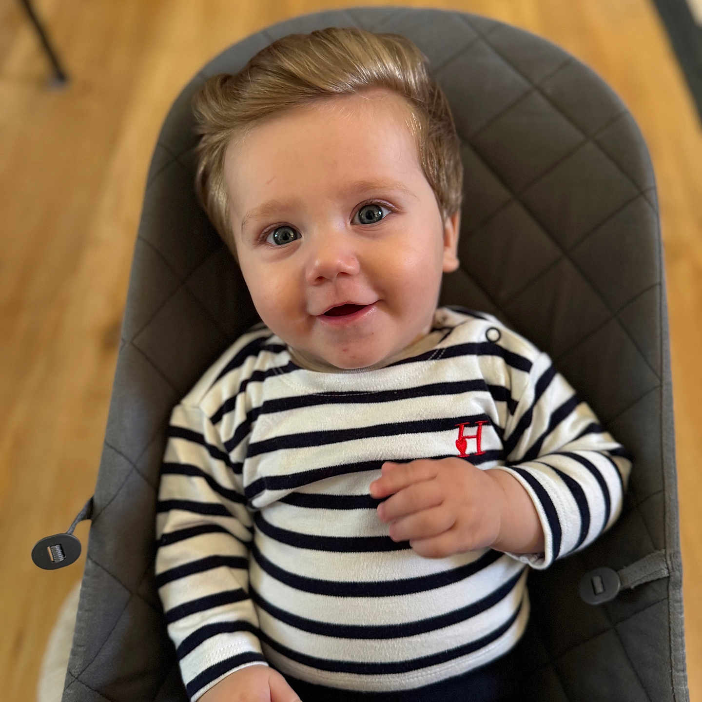 Louis participe au concours pour gagner de l'argent avec cette photo : baby, blue_eyes, child, clothing, comfortable, cute, face, hair, hand, happy, indoor, infant, padded_chair, person, portrait, sitting, smiling, striped_clothing, wooden_floor, young_child