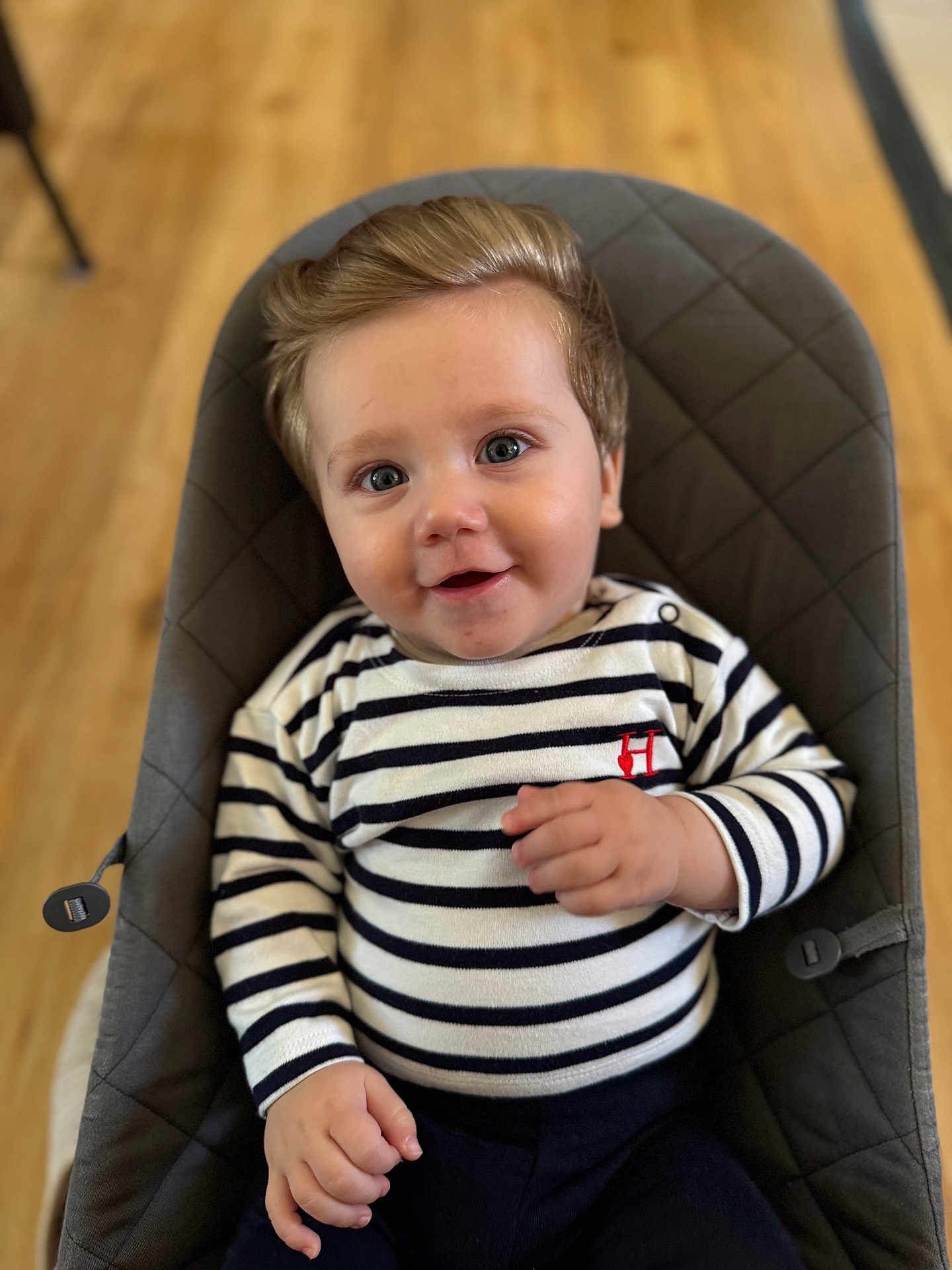 Louis participe au concours pour gagner de l'argent avec cette photo : baby, child, smiling, striped_clothing, blue_eyes, hair, padded_chair, indoor, wooden_floor, cute, portrait, hand, sitting, infant, happy, face, clothing, person, young_child, comfortable