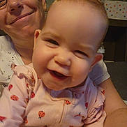 Lily joined the competition — help win amazing prizes! baby, adult, glasses, smile, pink_clothing, ladybug_pattern, onesie, indoor, closeup, face, happy, joyful, person, child, holding, family, casual, head, skin, expression