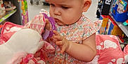 Lily joined the competition — help win amazing prizes! baby, child, shopping_cart, toy, plush, unicorn, teething_ring, store, shelf, shopping, pink, floral_dress, infant, girl, cute, indoor, retail, curious, person, cart