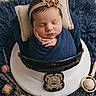 Ember joined the competition — help win amazing prizes! newborn, baby, sleeping, swaddled, blue_blanket, police_hat, flower_crown, dried_roses, soft_texture, pillow, portrait, cute, infant, headband, decorative_flowers, resting, indoors, closeup, peaceful, child