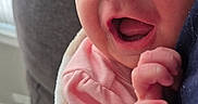 Ember is registered to the contest to win money with this photo: baby, blanket, close_up, couch, cozy, cute, expression, face, hand, happy, indoor, infant, newborn, person, pink_clothing, portrait, skin, smiling, wrapped, young_child
