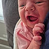 newborn, baby, infant, close_up, pink_clothing, blanket, smiling, happy, face, hand, skin, indoor, cozy, couch, person, portrait, cute, young_child, wrapped, expression