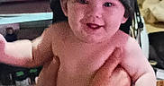 Daemon is registered to the contest to win money with this photo: baby, child, cap, hand, diaper, smile, indoor, person, face, happy, holding, clutter, furniture, adult, skin, headwear, portrait, infant, room, casual