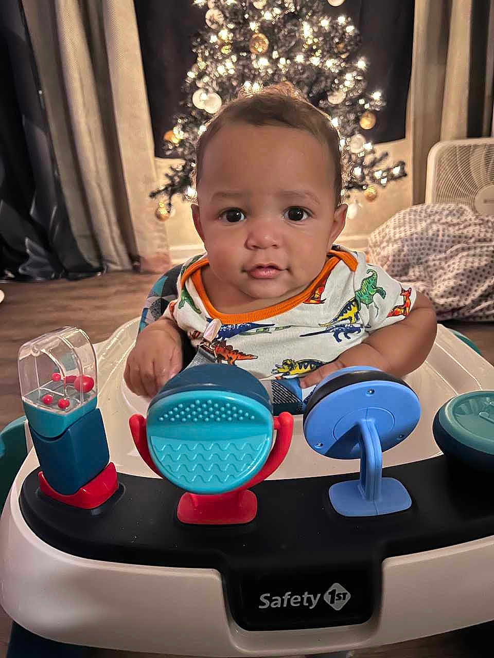 Rafael joined the competition — help win amazing prizes! baby, infant, walker, toy, face, child, indoor, christmas_tree, holiday, curious, smiling, clothing, floor, furniture, fan, blanket, home, decor, lighting, portrait