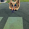 Dj is registered to the contest to win money with this photo: child, toddler, playground, swing, bucket_swing, outdoor, smiling, sitting, playground_surface, chains, socks, green_shirt, blue_shorts, building, grass, shrubs, parked_cars, portrait, daylight, phone_screenshot