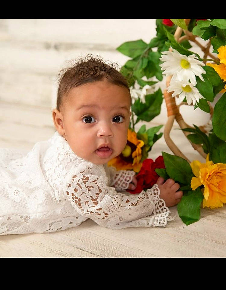 Zania is registered to the contest to win money with this photo: annual_plant, artificial_flower, baby, baby_toddler_clothing, child, cut_flowers, eye, fashion_accessory, flash_photography, flower, flower_arranging, flowering_plant, grass, happy, pattern, person, petal, plant, rose_family, sitting