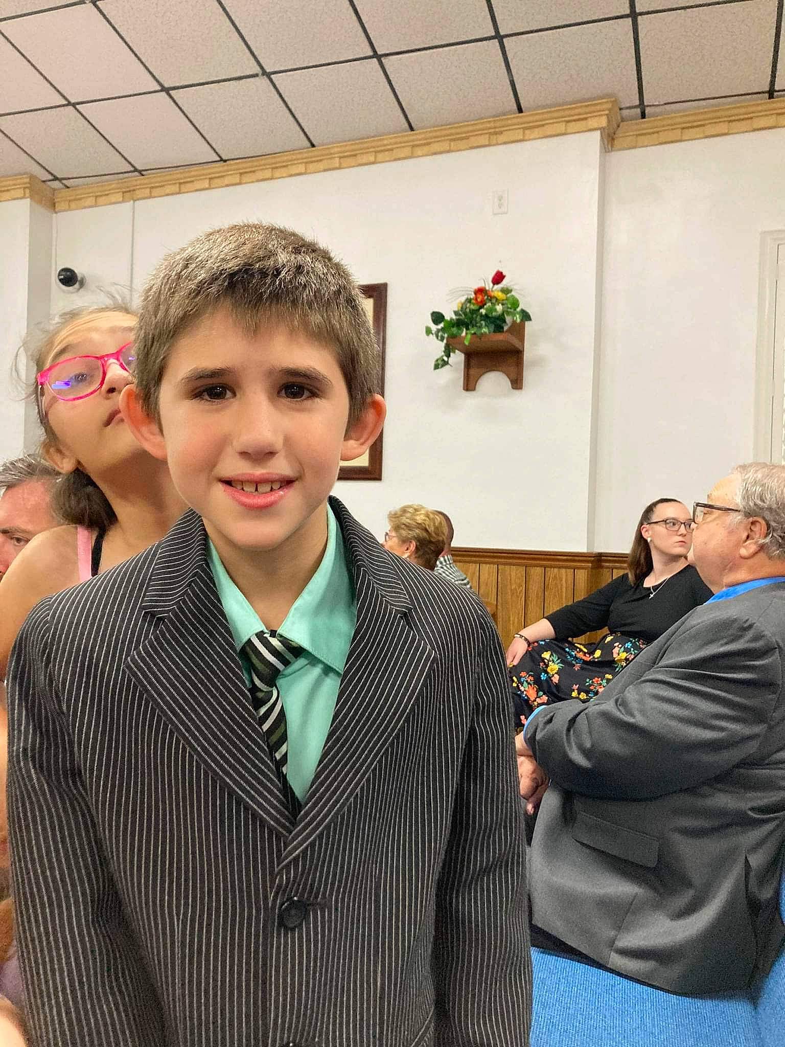 Elijah is registered to the contest to win money with this photo: bow_tie, ceremony, coat, event, eyewear, fashion_accessory, fashion_design, flooring, formal_wear, fun, happy, houseplant, joy, official, outerwear, person, room, smile, suit, tie