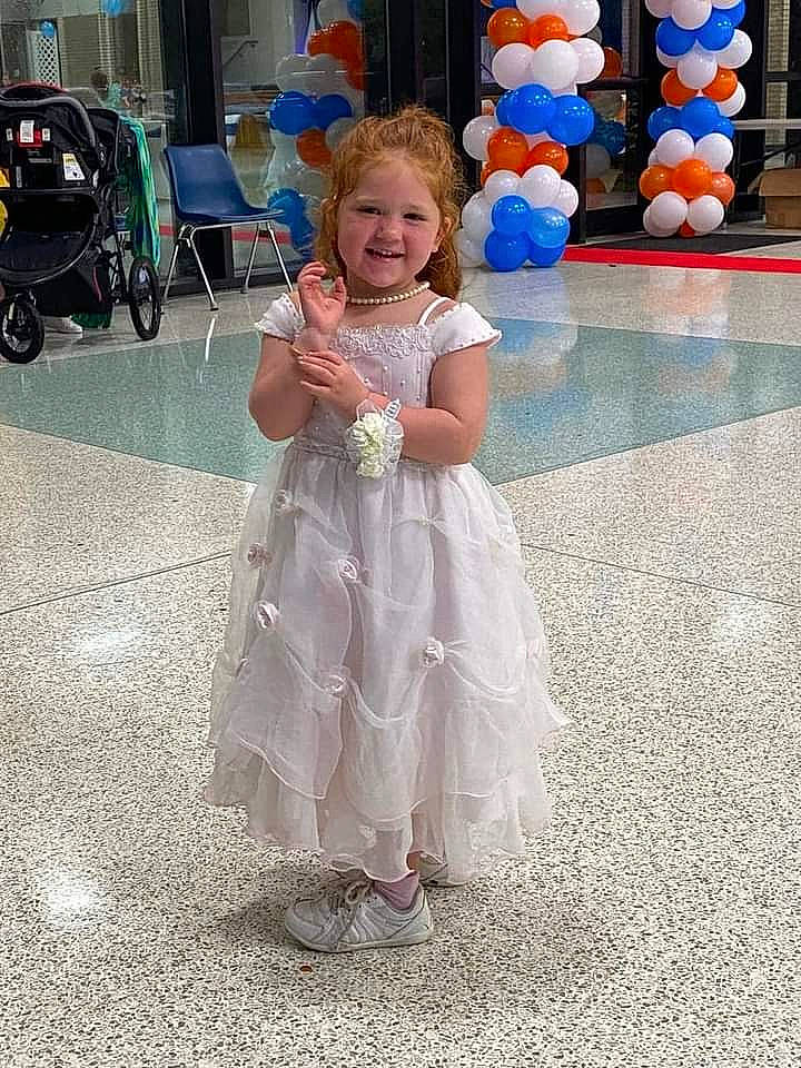 Rebecca is registered to the contest to win money with this photo: baby_toddler_clothing, balloon, bicycle_wheel, child, dress, event, fun, happy, joy, leisure, organ, party_supply, person, photograph, recreation, smile, snapshot, standing, tire, toddler