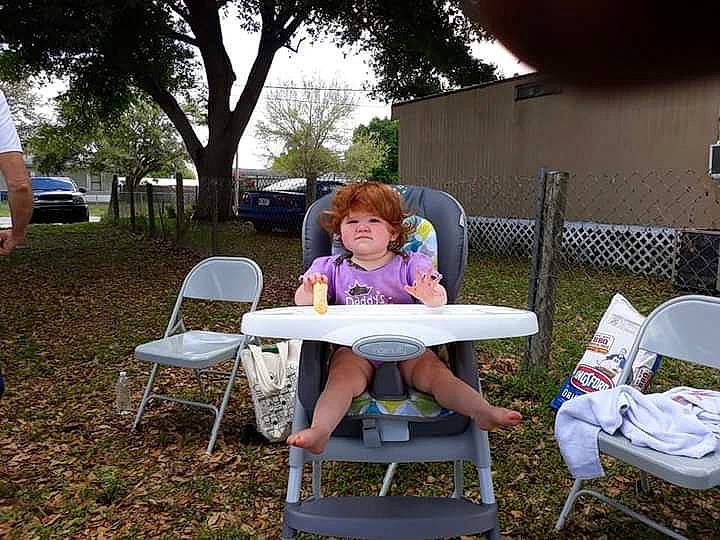 Rebecca joined the competition — help win amazing prizes! chair, event, fun, furniture, garden, grass, lap, lawn, leisure, outdoor_furniture, outdoor_table, patio, person, plant, recreation, sitting, sky, table, toddler, tree