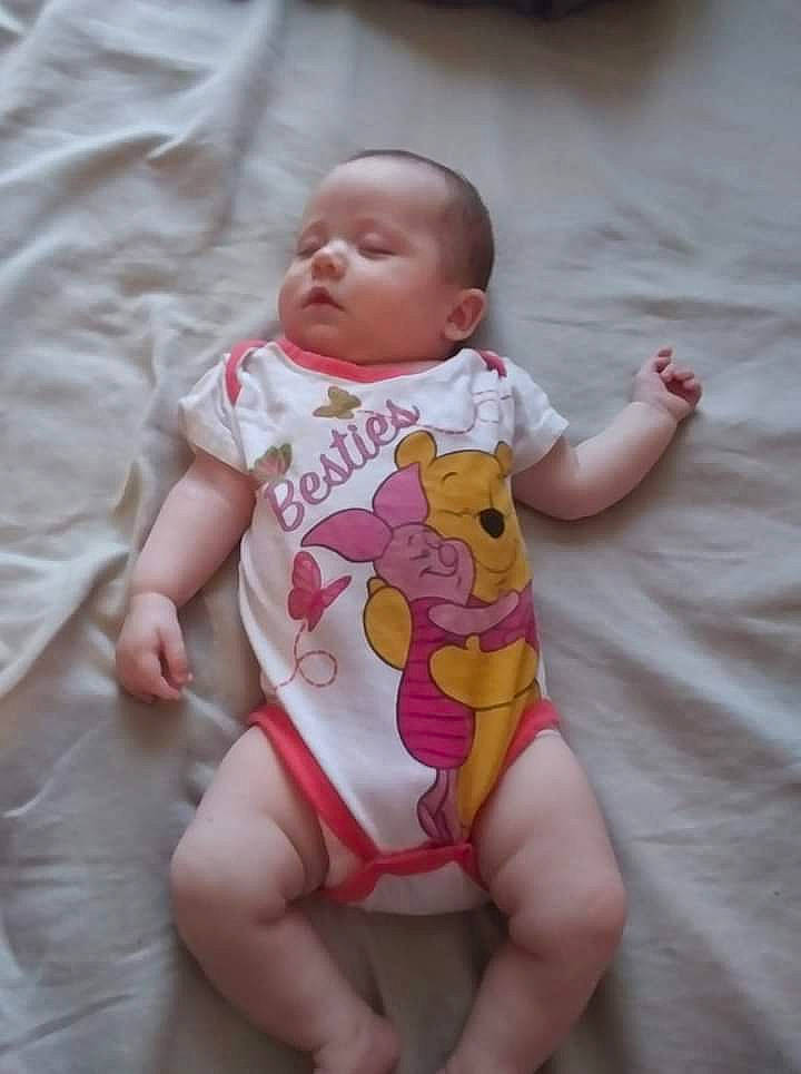 Astridr is registered to the contest to win money with this photo: baby, baby_toddler_clothing, cheek, comfort, eye, face, finger, human_body, infant_bodysuit, knee, leg, lip, mouth, person, pink, skin, sleeve, stomach, textile, thigh