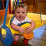 Lenny joined the competition — help win amazing prizes! baby, child, indoor, swing, yellow, duck, toy, smiling, happy, wooden_floor, cabinet, red_socks, play, cute, infant, person, furniture, hands, face, expression