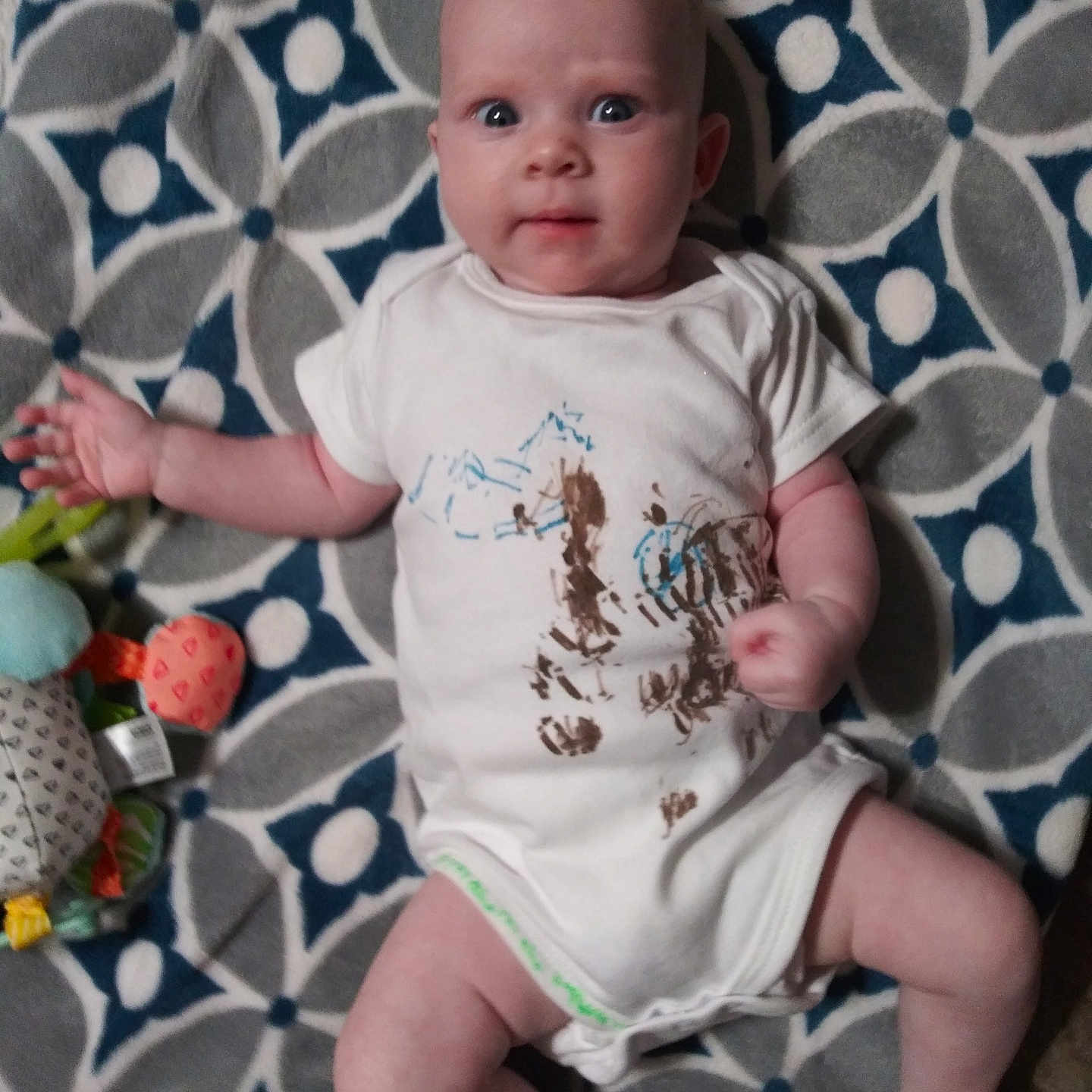 Maya joined the competition — help win amazing prizes! baby, blanket, child, clenched_fist, cute, expression, face, floor, foot, hand, head, indoor, infant, legs, onesie, pattern, playful, skin, toy, wide_eyes