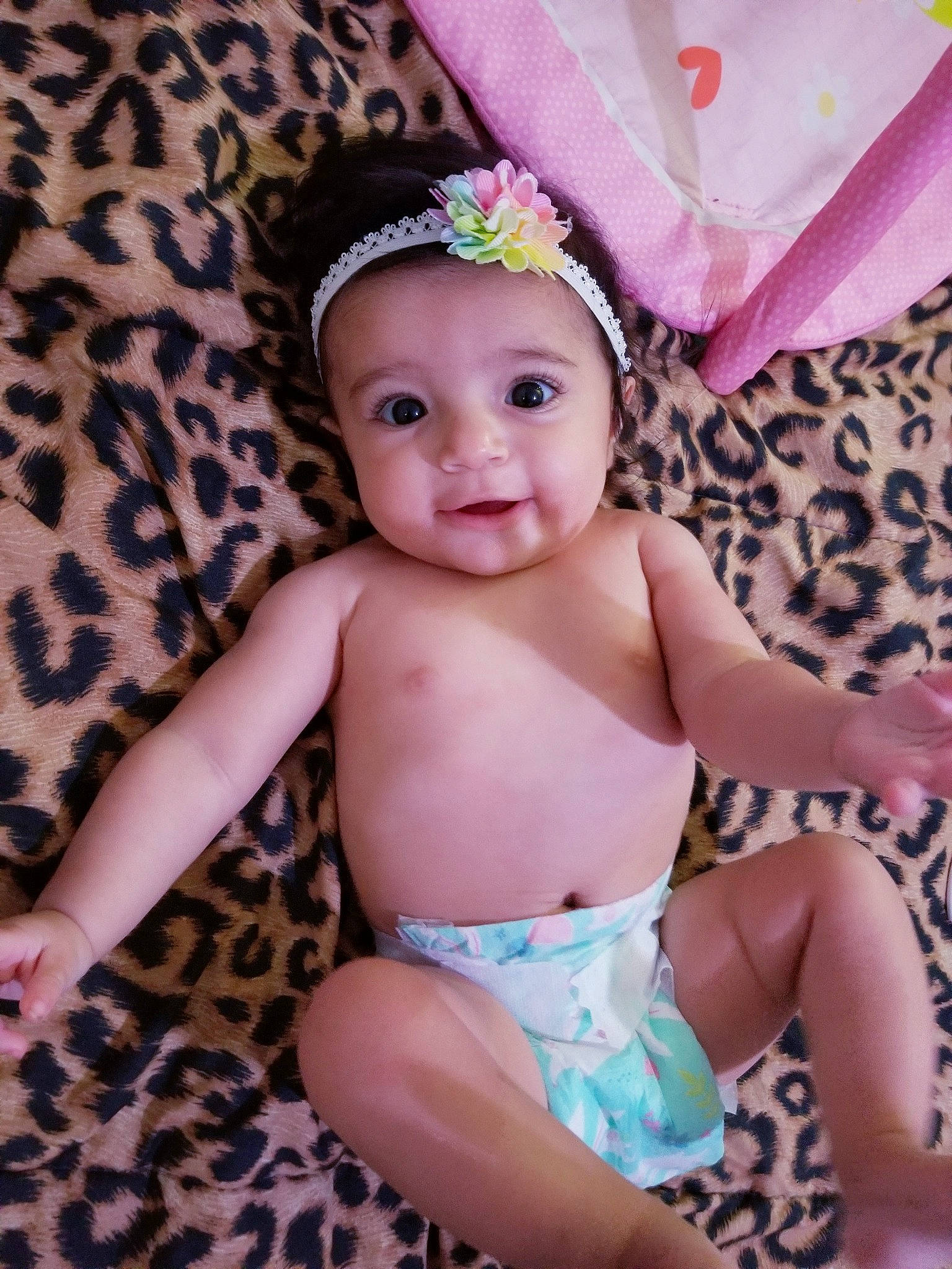 Melody Ann is registered to the contest to win money with this photo: abdomen, baby, baby_toddler_clothing, eye, face, finger, happy, head, headband, headpiece, headwear, iris, jewellery, pattern, person, petal, pink, sitting, skin, smile