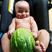 Steve joined the competition — help win amazing prizes! baby, child, infant, watermelon, fruit, smiling, sitting, barefoot, portrait, indoors, chair, close_up, face, eyes, hands, feet, skin, happy, funny, photography