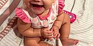 Shiloh is registered to the contest to win money with this photo: baby, bedspread, child, cute, eyes, face, feet, hair, hands, happy, indoors, infant, mouth, person, pink_clothing, polka_dot, sitting, skin, smiling, toy