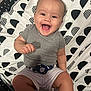 Shiloh is registered to the contest to win money with this photo: baby, black_and_white, bright, child, cute, face, gray_shirt, hand, happy, indoor, infant, joyful, legs, patterned_blanket, people, portrait, sitting, smiling, toddler, white_shorts
