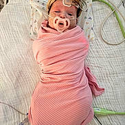 Riley joined the competition — help win amazing prizes! baby, swaddle, hospital_bed, medical_tubes, pacifier, headband, sensor, blanket, infant, person, medical_equipment, lying_down, cute, newborn, pink_clothing, bed, healthcare, child, face, hospital