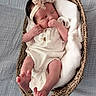 Riley is registered to the contest to win money with this photo: baby, newborn, sleeping, basket, blanket, headband, lace, clothing, infant, soft, cozy, peaceful, skin, foot, hand, portrait, indoor, fabric, texture, cute