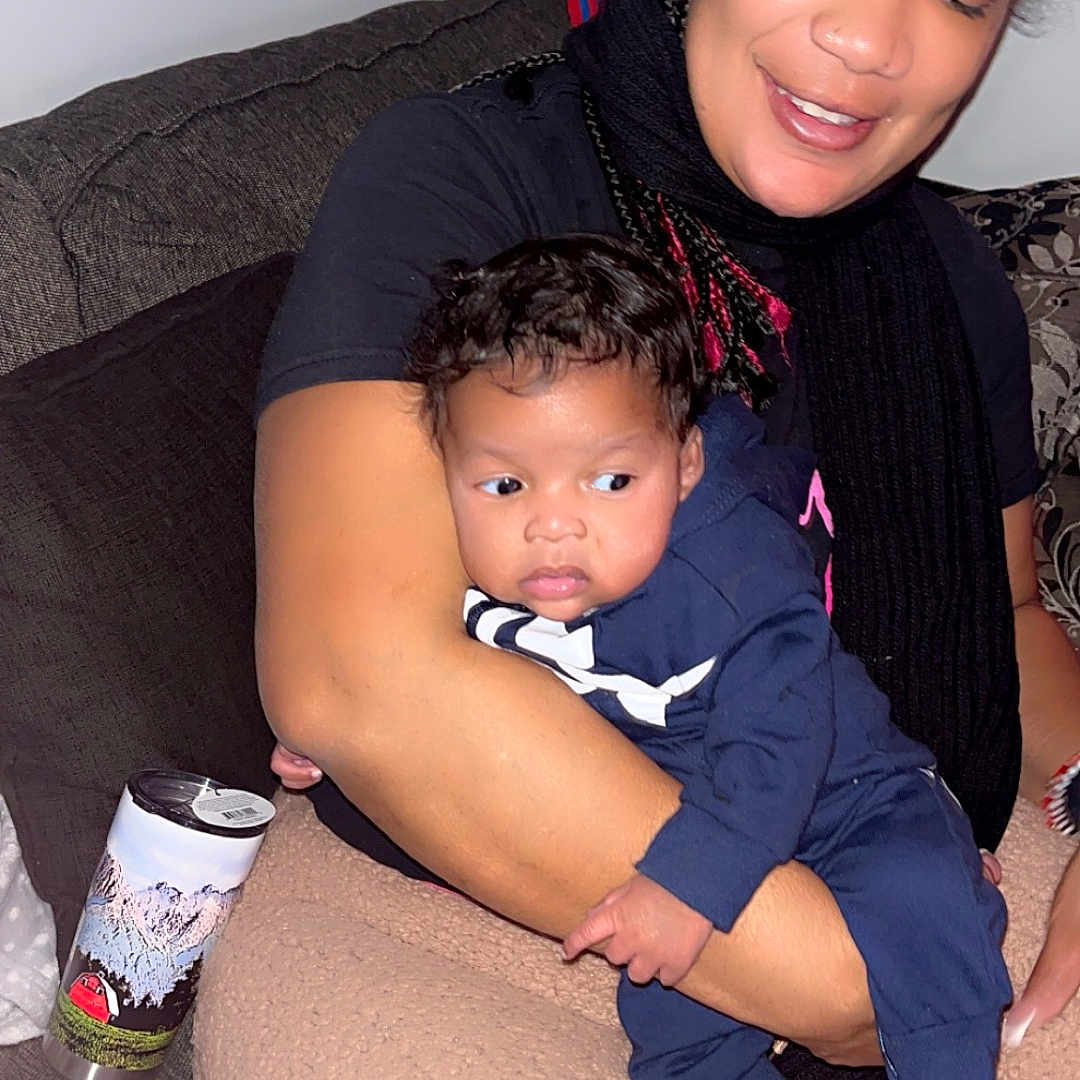 Shakeel joined the competition — help win amazing prizes! woman, baby, child, indoor, smile, holding, couch, pillow, clothing, hair, person, furniture, relaxed, casual, footwear, skin, happy, portrait, can, floor