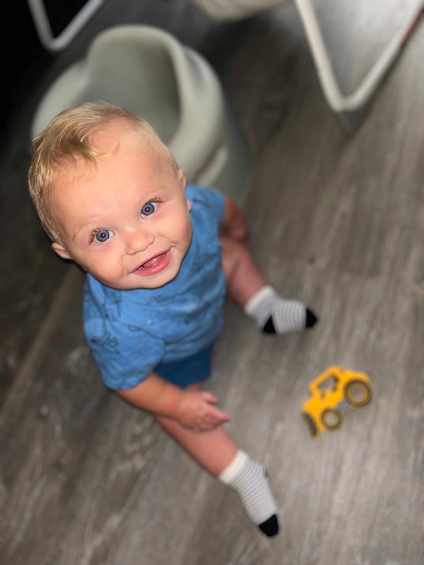 Aspen joined the competition — help win amazing prizes! toddler, child, smiling, blue_shirt, striped_socks, toy_truck, wooden_floor, indoor, happy, blond_hair, blue_eyes, sitting, floor, playtime, cute, person, baby, looking_up, small_toy, casual_clothing