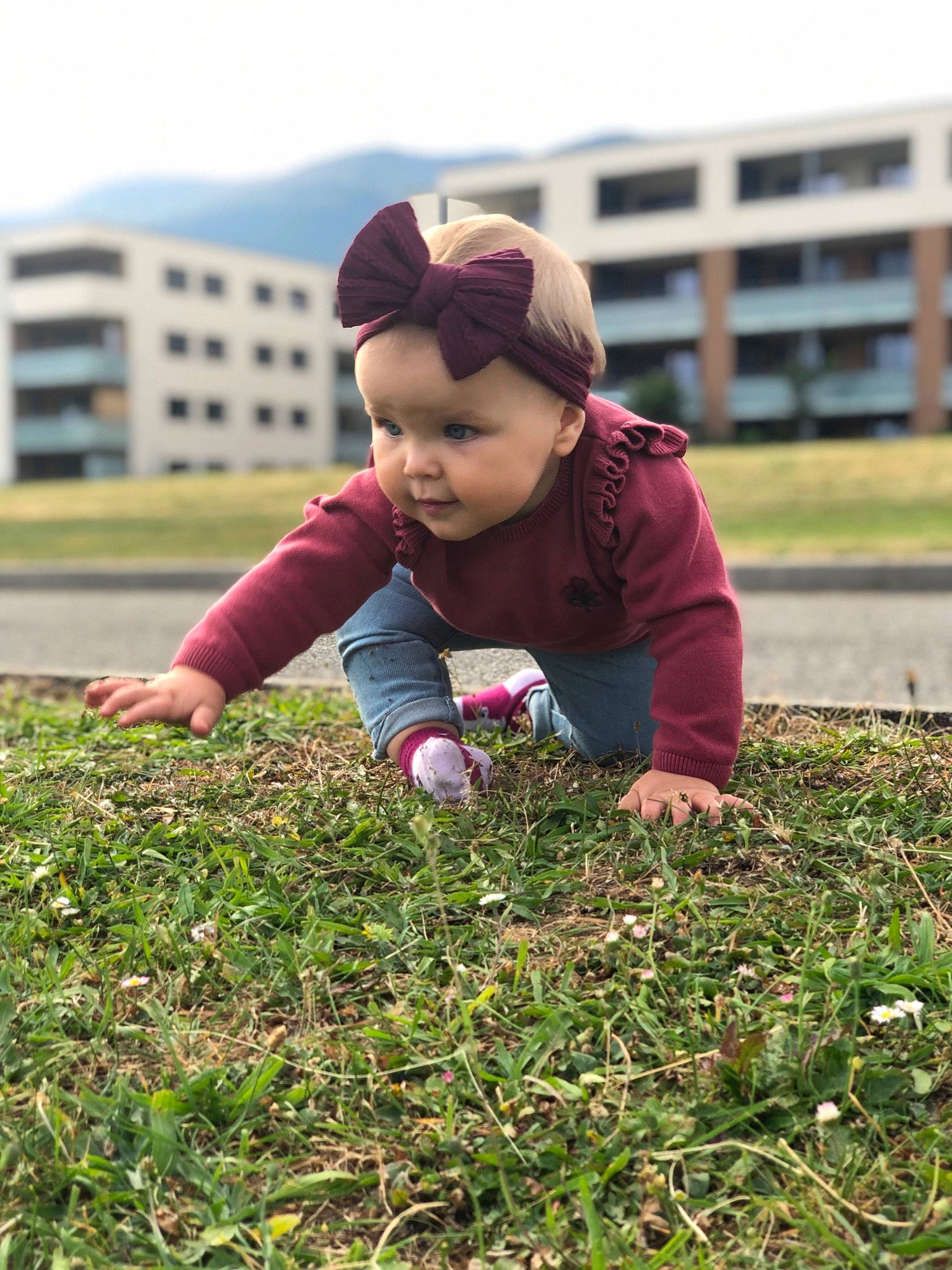 Livia a rejoint le concours — aidez-le/la à gagner de superbes lots ! baby, cap, child, face, field, garden, grass, grassland, groundcover, happy, jacket, lawn, leaf, people_in_nature, person, plant, plantation, sitting, sky, soil